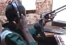 Editing radio news bulletins Journalist Bakhita Aluel adjusting the microphone at Radio Easter in Yei in South Sudan
