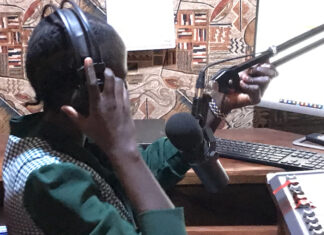 Editing radio news bulletins Journalist Bakhita Aluel adjusting the microphone at Radio Easter in Yei in South Sudan