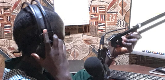 Journalist Bakhita Aluel adjusting the microphone at Radio Easter in Yei in South Sudan